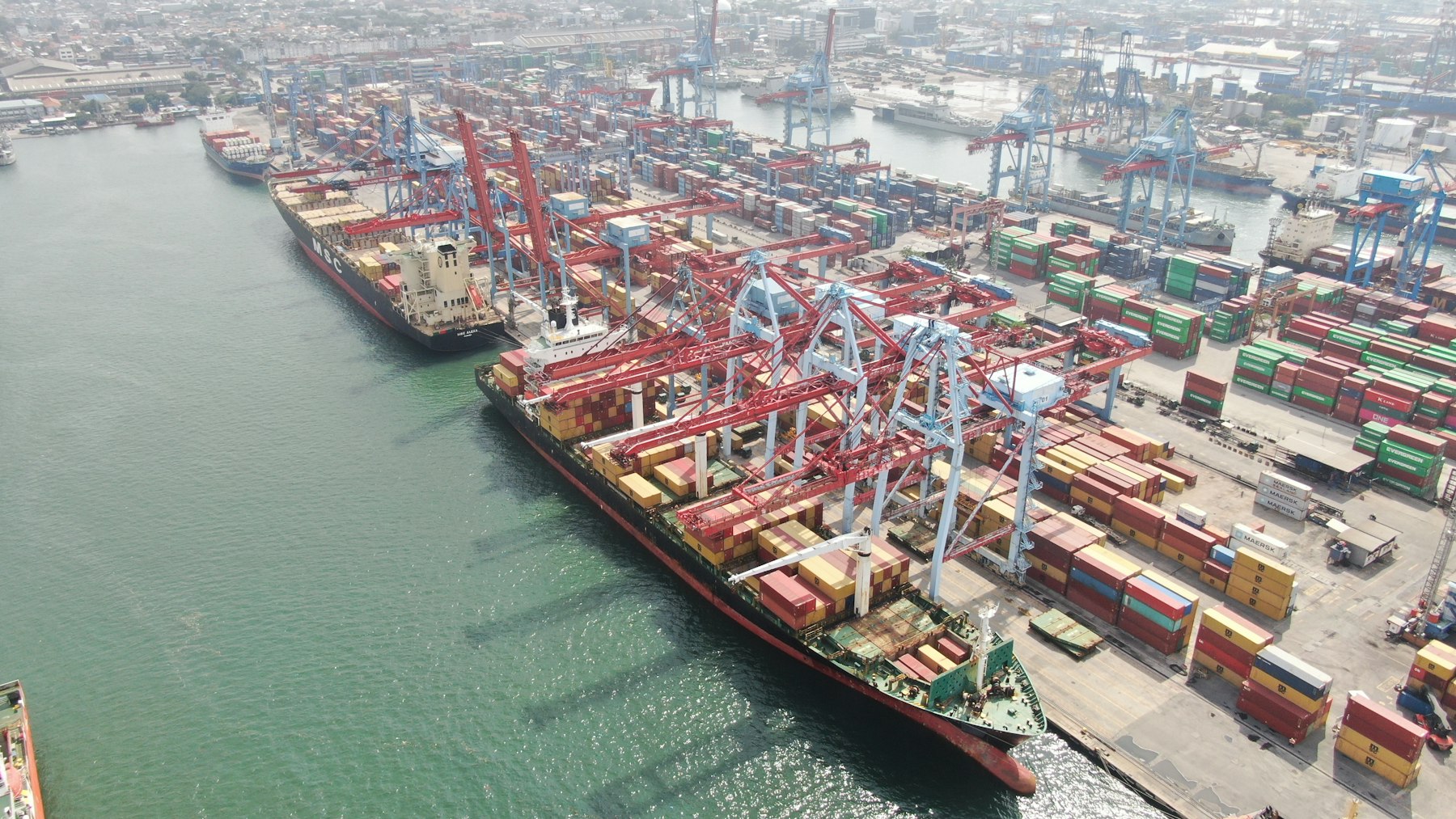 Container vessels, cranes, and cargo stacks inside a working port